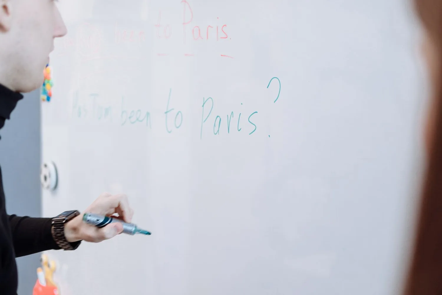 Profesor explicando una clase de inglés en la pizarra