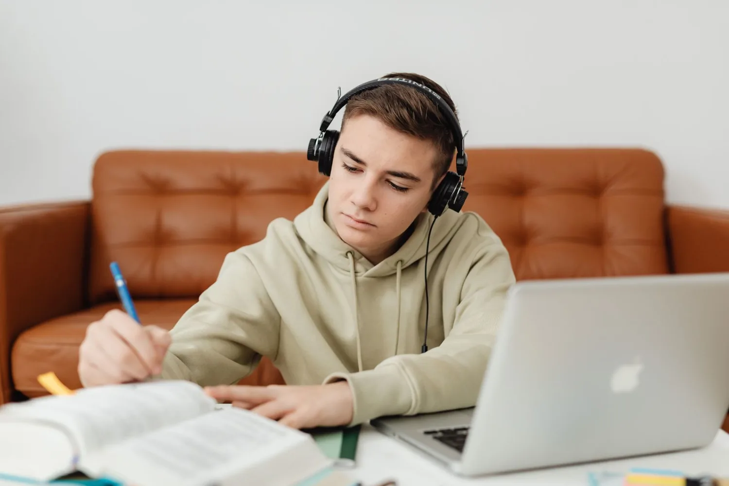 Adolescente estudiando inglés con auriculares y portátil