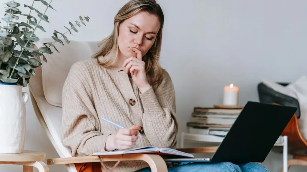 Estudiante adulta comparando opciones con cuaderno y portátil antes de elegir su certificado de inglés